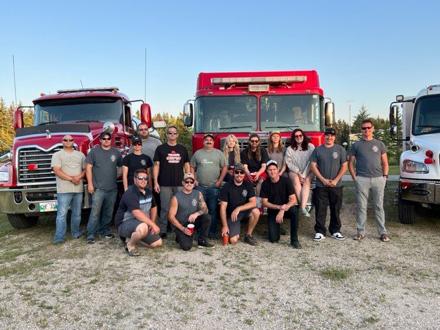 Group photo of the RM of Reynolds Fire Department in front of the Fire Truck and Water Truck.