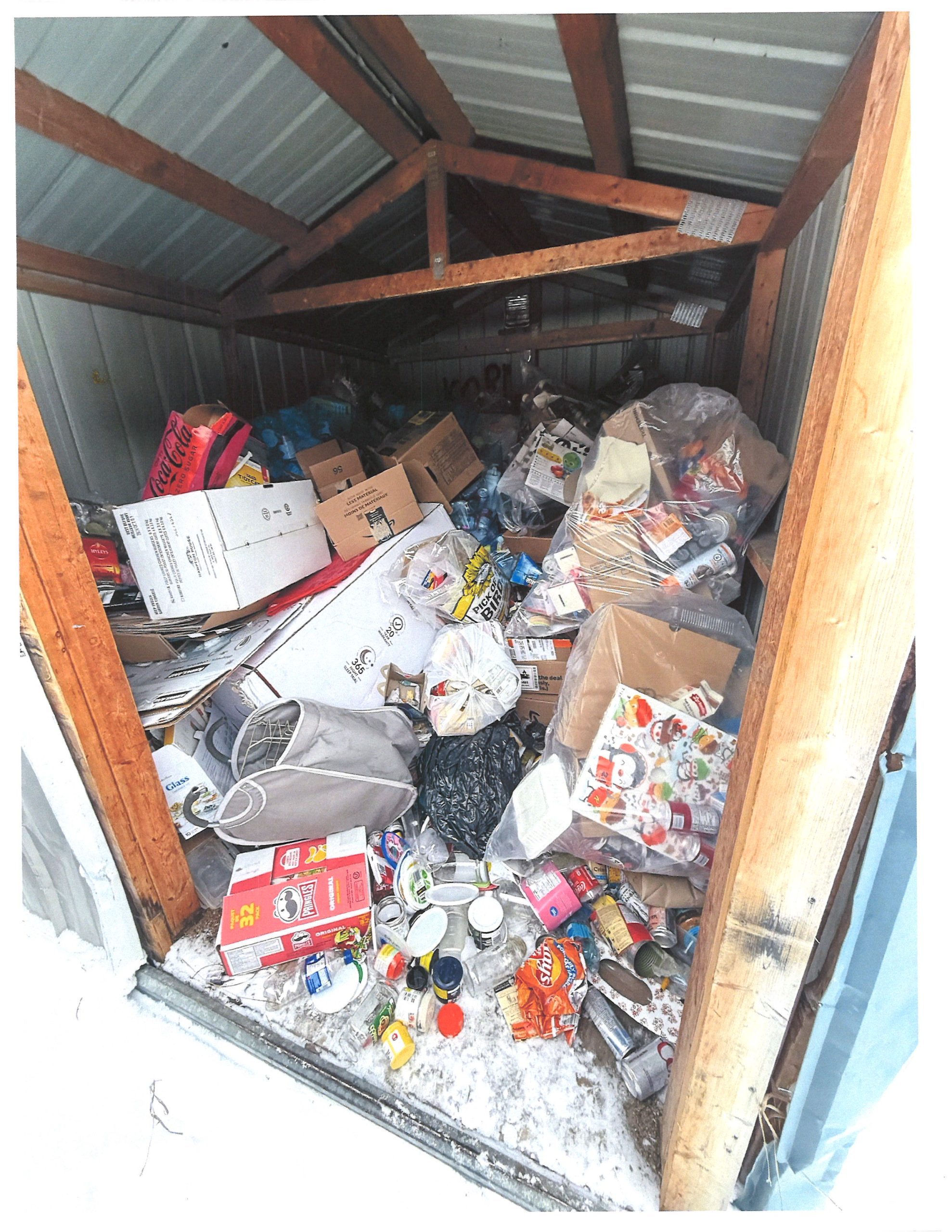 Image of Rural Municipality of Reynolds recycling shed showing misuse with unbagged recycling and garbage.